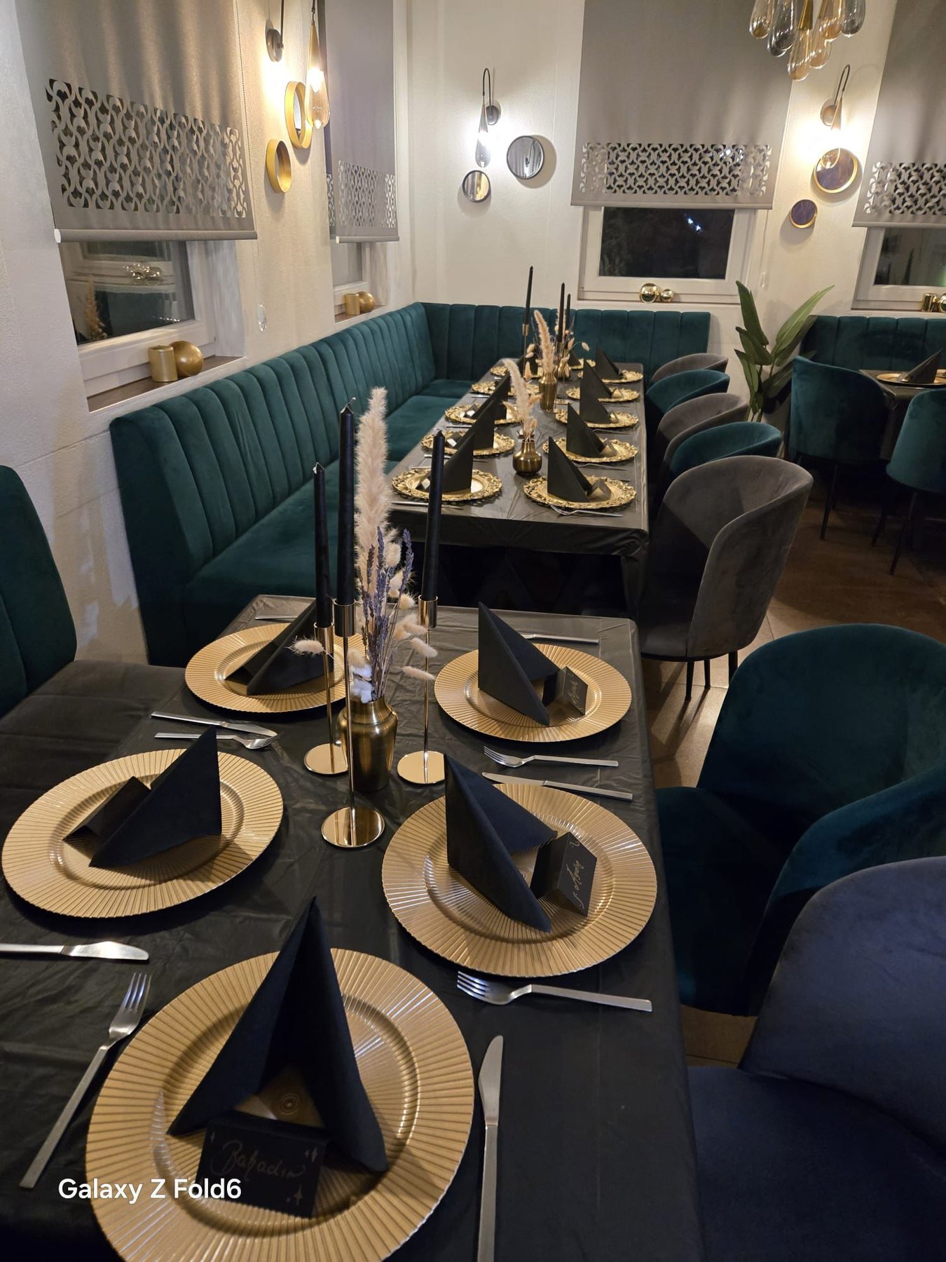 Festlich gedeckter Tisch mit Goldtellern und Kerzen