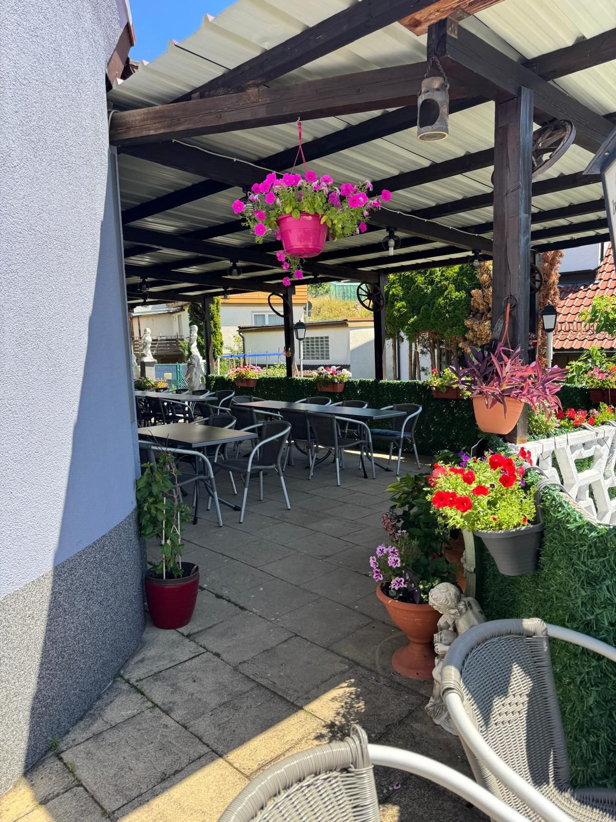 Begrünte Terrasse mit Blumenampeln